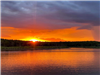 Sun shinning behind the trees at Skiatook Lake during sunset.