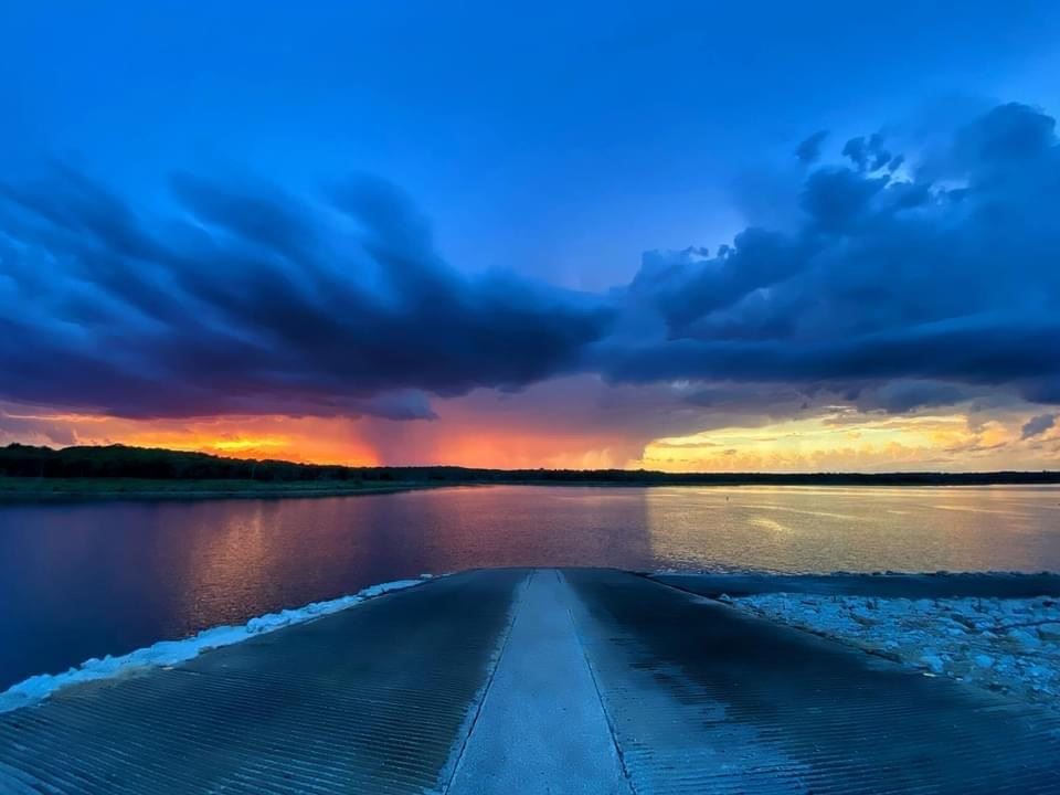 A boat ramp at the lake during sunset.